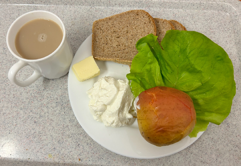 Na zdjęciu znajduje się: Kawa z mlekiem, Chleb Graham, Masło extra 82%, Serek homo. naturalny, Jabłko pieczone, Sałata zielona